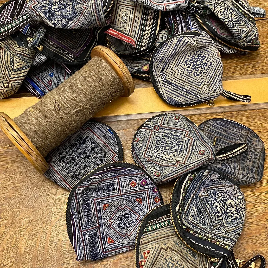Coin purses and a spool of thread made from Hmong indigo and brocade fabric